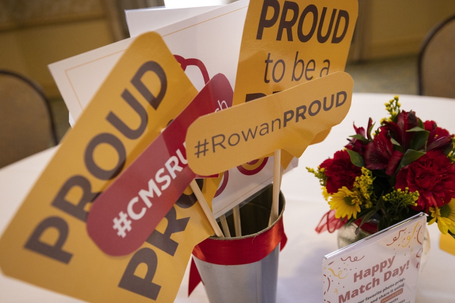 A photo featuring CMSRU-branded photo props next to a floral arrangement on a table.