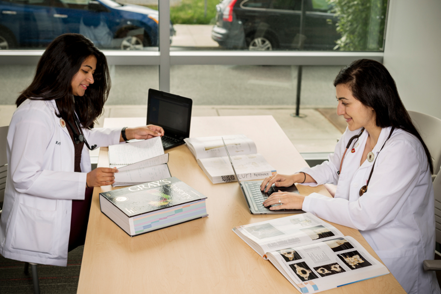 Two CMSRU students work together at a desk.