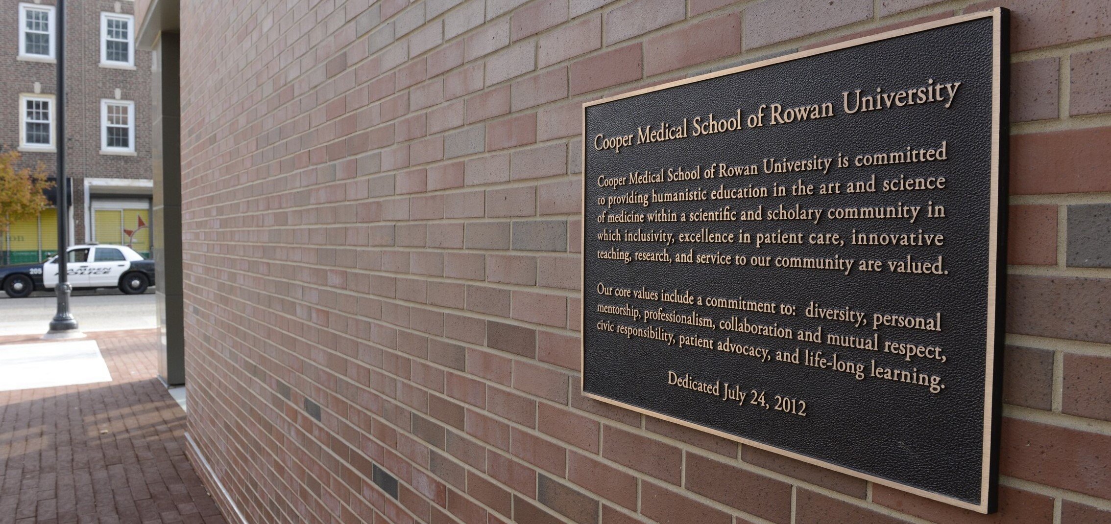 A photo featuring a plaque located on the exterior of the CMSRU Medical Education Building. This plaque showcases CMSRU's mission statement.