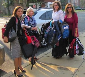 CMSRU staff members are photographed holding backpacks.