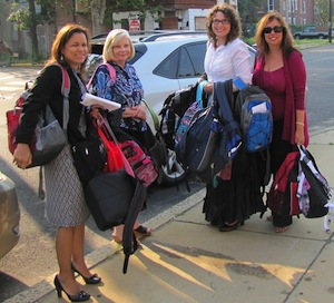 CMSRU staff members are photographed holding backpacks.