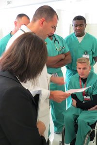 A photo of a professor speaking to medical students.