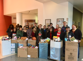 CMSRU students, faculty and staff pose for a photo with all of the gifts they collected to donate to local children around the holidays.