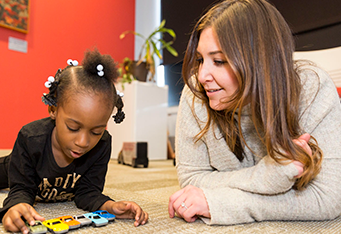 A CMSRU student is featured spending time with a young child.