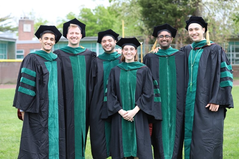 A group of recent CMSRU graduates pose together for a photo at their Commencement ceremony.