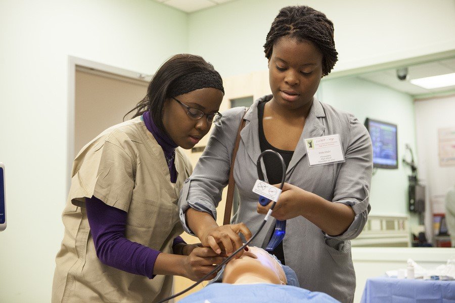 A CMSRU student poses with a student at a Junior Urban Medical Pioneers (JUMP) event.
