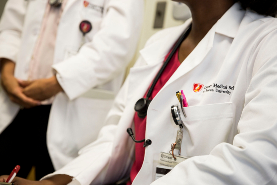 An environmental portrait of two CMSRU student in their CMSRU White Coats.