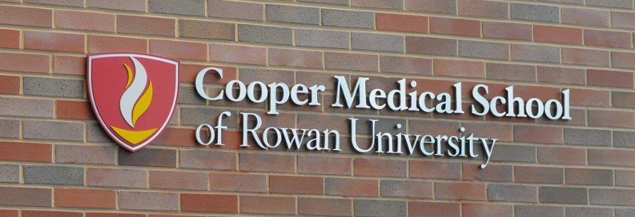 This image features the Cooper Medical School of Rowan University (CMSRU) logo on a brick wall.