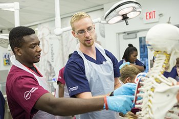 Two students are featured participating in the MEDacademy Masters program.