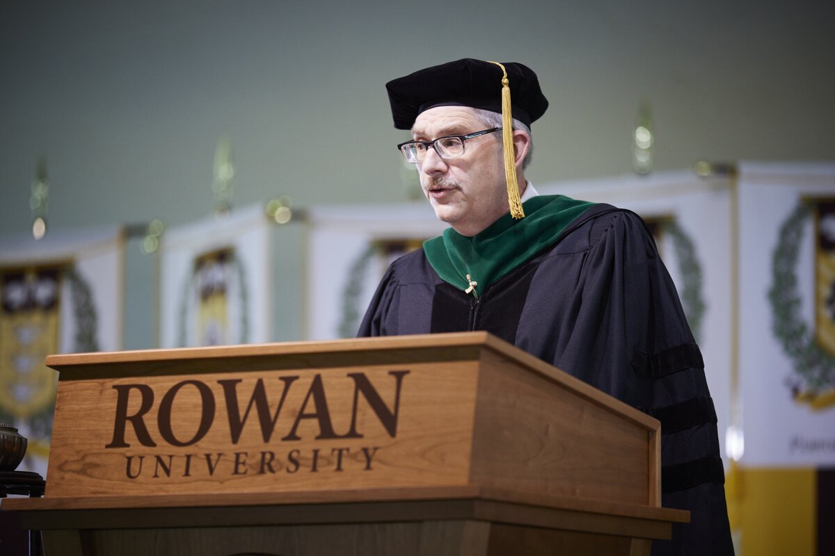 William Kocher, MD, senior associate dean for admissions at CMSRU stands at a podium to address the crowd at a CMSRU Commencement ceremony.