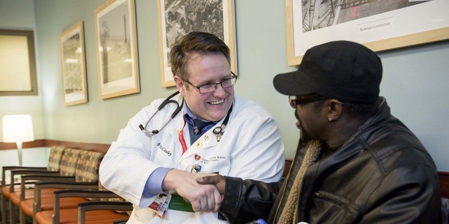 A photo of a CMSRU student shaking hands with a member of the community.