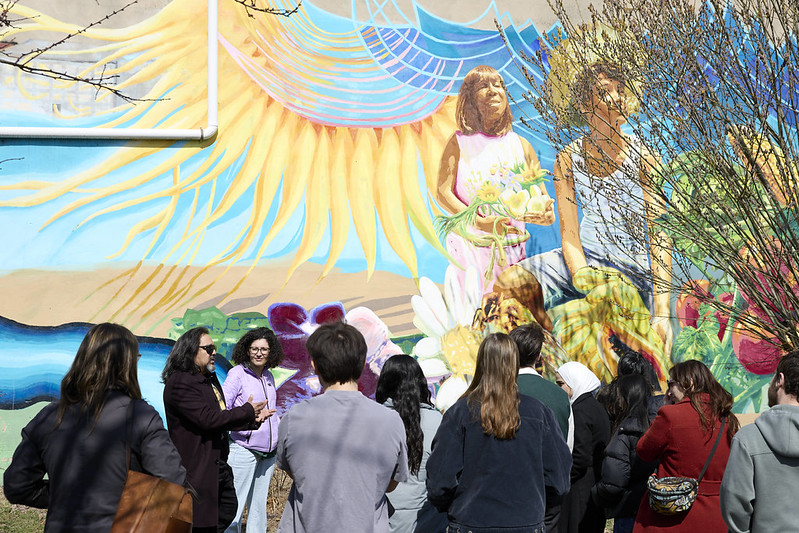 A photo of CMSRU students and faculty observing a mural in Camden.