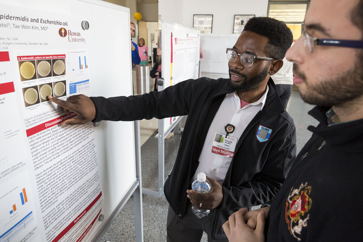 A photo of two CMSRU students reviewing a research poster together.