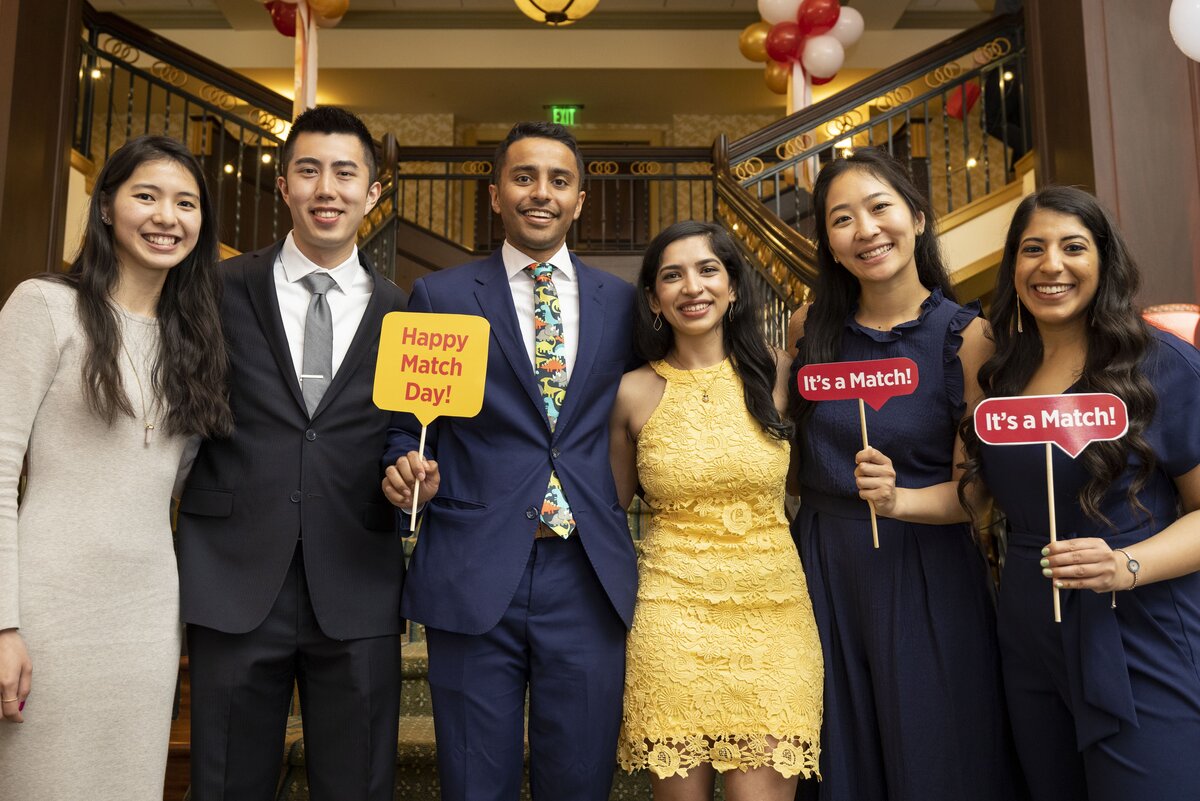 A group of CMSRU students pose together holding photo props during their Match Day Celebration.